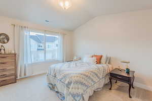 Carpeted bedroom with vaulted ceiling