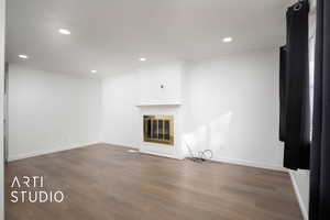 Unfurnished living room with ornamental molding and dark wood-type flooring