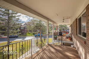 Wooden deck featuring a lawn and a porch