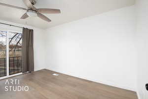 Spare room with wood-type flooring and ceiling fan