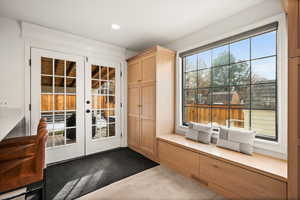 Entryway with carpet, plenty of natural light, and french doors