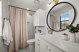 Bathroom featuring a shower with curtain, vanity, ornamental molding, and toilet