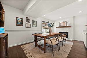 Dining room featuring dark hardwood / wood-style floors and a brick fireplace