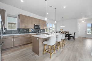 Kitchen featuring sink, a center island with sink, a healthy amount of sunlight, and appliances with stainless steel finishes