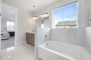 Bathroom with vanity, tile patterned floors, and a bathtub