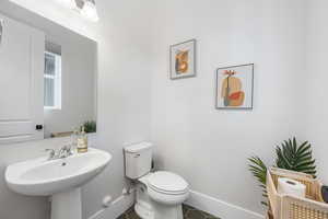 Bathroom with tile patterned flooring, toilet, and sink