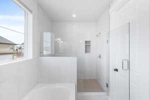 Bathroom with separate shower and tub, tile walls, and a healthy amount of sunlight