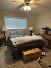 Carpeted bedroom featuring ceiling fan