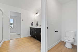 Bathroom with hardwood / wood-style flooring, vanity, and toilet