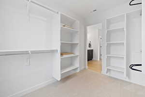 Spacious closet with light carpet