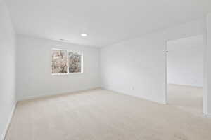 Unfurnished room featuring light carpet