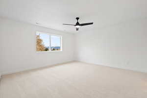 Carpeted empty room with ceiling fan