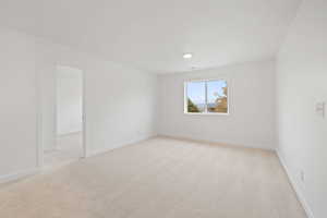 Unfurnished room featuring light colored carpet