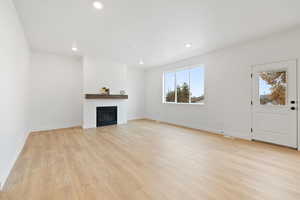 Unfurnished living room with a healthy amount of sunlight and light hardwood / wood-style floors