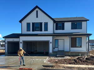 View of front of home featuring board and batten siding, driveway, and an attached garage