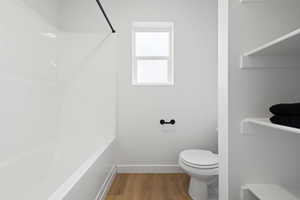 Bathroom with hardwood / wood-style flooring and toilet