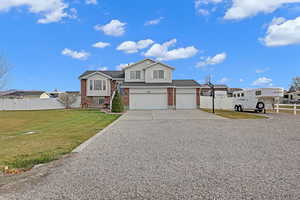 View of front facade featuring a garage and a front lawn