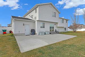 Back of property with a lawn and a patio area