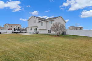 Rear view of property featuring a lawn, a patio area, and cooling unit