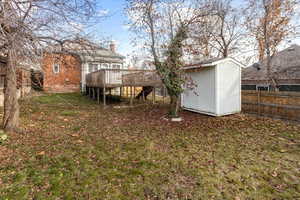 View of yard featuring a storage shed and a wooden deck