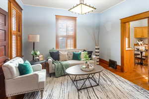 Living room featuring wood-type flooring and ornamental molding