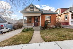 Bungalow-style home featuring a porch and a front lawn