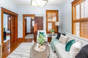 Living room featuring wood-type flooring and ornamental molding