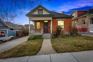 View of front of house with a yard and a porch