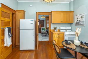 Kitchen featuring wood-type flooring and white appliances