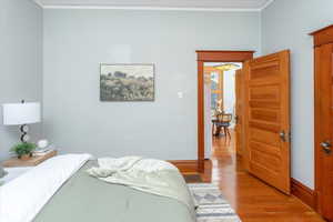 Bedroom with crown molding and light hardwood / wood-style floors