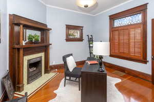 Office space with wood-type flooring and crown molding