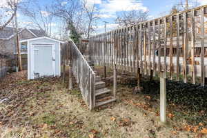 Exterior space with a wooden deck and a storage shed