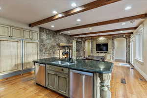 Kitchen featuring a kitchen island with sink, sink, stainless steel dishwasher, and light hardwood / wood-style floors