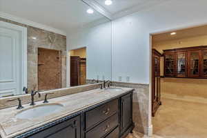 Master Bathroom featuring vanity, ornamental molding, and tile walls