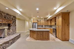 Kitchen featuring a center island, light colored carpet, appliances with stainless steel finishes, and tasteful backsplash