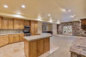 Kitchen with a center island, french doors, tasteful backsplash, light colored carpet, and appliances with stainless steel finishes