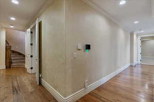 Corridor featuring light hardwood / wood-style floors and ornamental molding