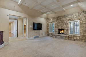 Master Bedroom featuring a fireplace, a high ceiling, light colored carpet, and beamed ceiling