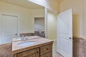 Bathroom with vanity and tile walls