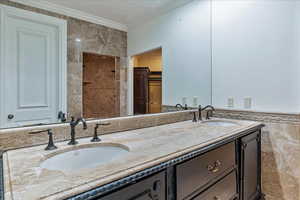 Master Bathroom featuring vanity, tile walls, and ornamental molding