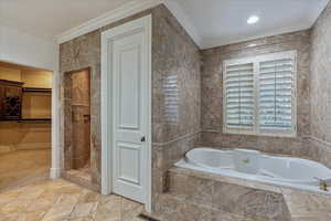 Master Bathroom featuring separate shower and tub, tile walls, and crown molding