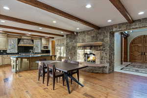 Dining area with beam ceiling and light hardwood / wood-style flooring