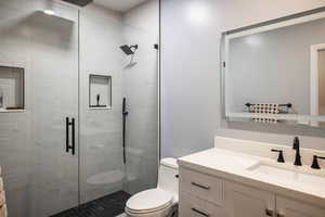 Bathroom with vanity, toilet, and an enclosed shower