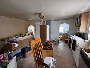 Kitchen featuring ceiling fan and white cabinetry