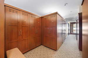 Hallway featuring light colored carpet