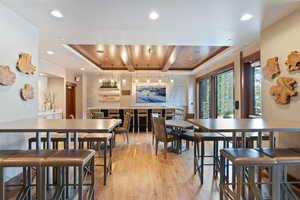 Dining room with a tray ceiling, wood ceiling, and light wood-type flooring