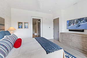 Bedroom featuring connected bathroom and light hardwood / wood-style flooring