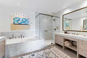 Bathroom with hardwood / wood-style floors, vanity, and independent shower and bath