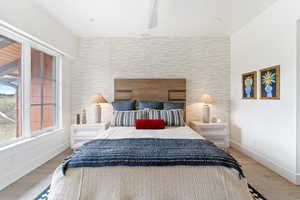 Bedroom featuring hardwood / wood-style flooring and tile walls