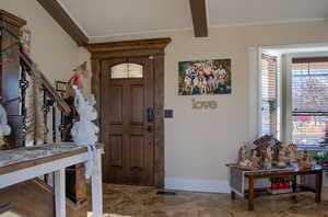 Foyer entrance featuring beam ceiling and ornamental molding